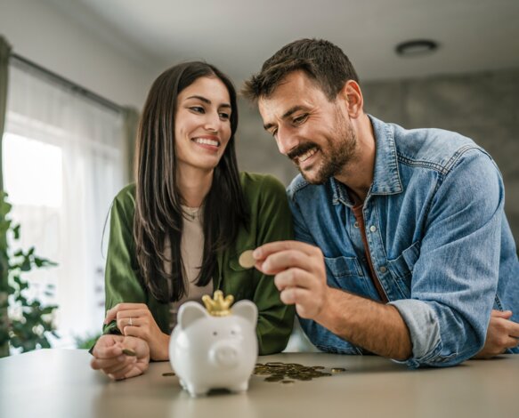 Junges Paar mit Sparschwein – Finanzielle Vorteile und Kosteneinsparung bei Energie