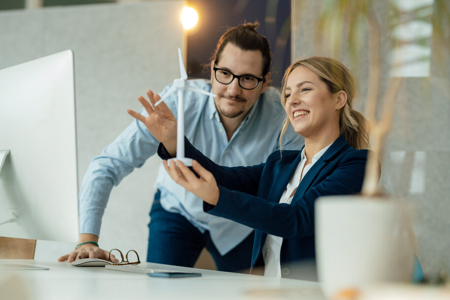 Mitarbeiter betrachten ein Windrad-Modell – Symbol für umfassende Energielösungen und die Energiewende bei MONTANA