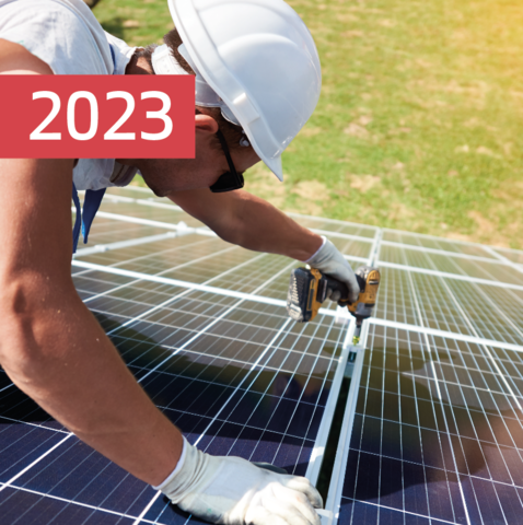 Ein Handwerker mit Schutzhelm montiert Solarmodule – Meilenstein 2023: MONTANAs Einstieg in die Photovoltaik