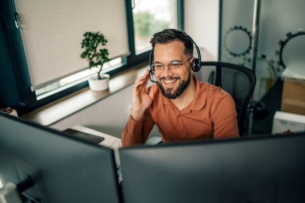Ein freundlicher MONTANA Servicemitarbeiter mit Brille und Headset an seinem modernen Arbeitsplatz – Wir nehmen uns Zeit für Ihre Fragen rund um Energie