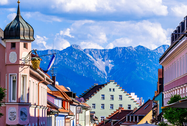 Bunte historische Häuserfassaden mit Alpenpanorama im Hintergrund – MONTANA Heizöl Lieferung in Murnau und Penzberg