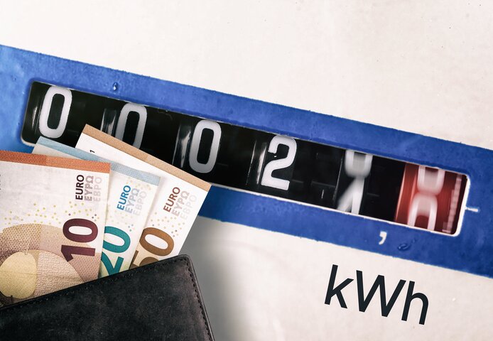 Nahaufnahme eines Gaszählers mit eingesteckten Euro-Geldscheinen – Informationen zur Zusammensetzung des Gaspreises