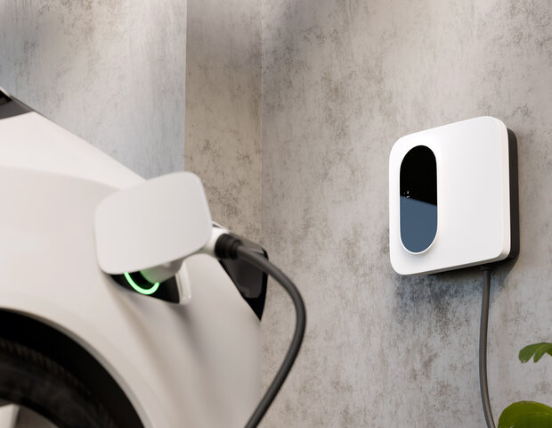 Elektroauto lädt an einer modernen Wallbox an der Hauswand – Das ideale und schnelle Bindeglied zwischen PV-Anlage und E-Auto für zu Hause