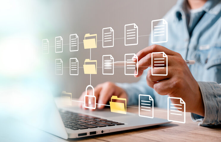 Person am Laptop organisiert vernetzte digitale Dokumente und Ordner – Strukturierte und sichere Jahresabrechnung für Hausverwaltungen