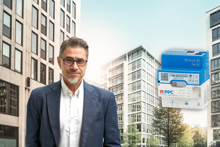 Experte vor einem Gebäudekomplex neben einem digitalen Smart Meter – Informationen zum Rollout intelligenter Zähler