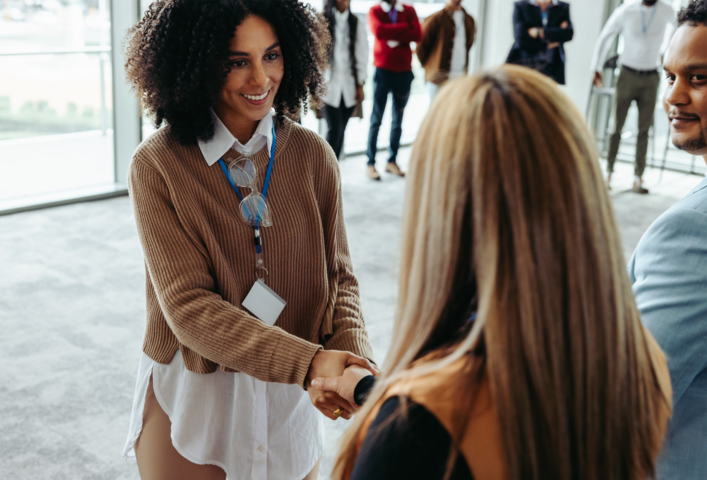 Zwei Frauen bei einer herzlichen Begrüßung per Handschlag – Networking und Expertenaustausch
