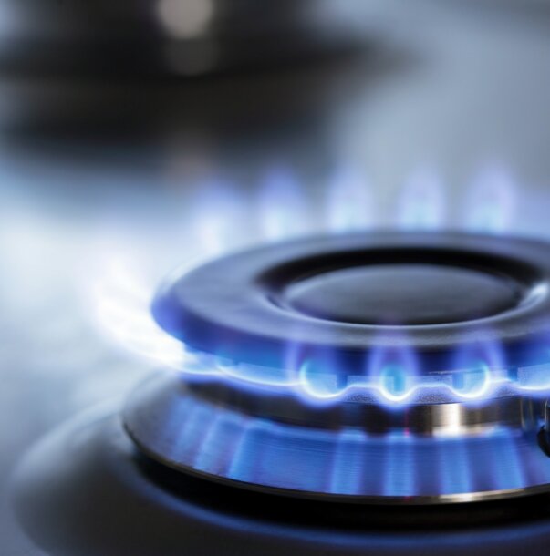 Nahaufnahme eines Gasbrenners mit blauen Flammen – Effiziente Erdgas-Versorgung und Rahmenverträge für Ihre Immobilien bei MONTANA