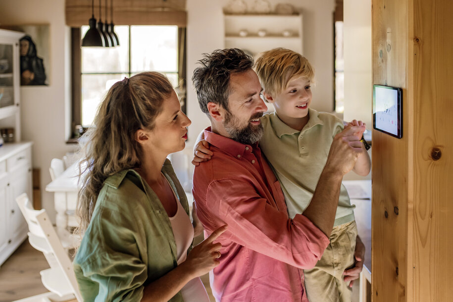 Eltern und Kind vor einem Smart-Home-Terminal – Symbol für transparente Gaspreise