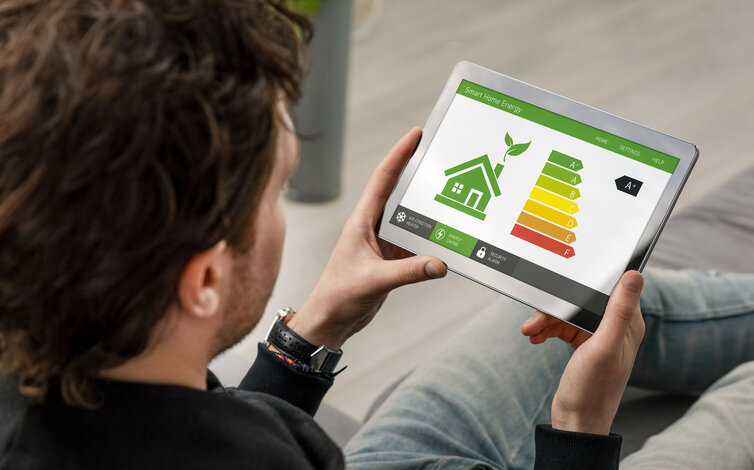 Mann betrachtet Energieeffizienz-Skala auf einem Tablet – Service zur Erstellung von Energieausweisen