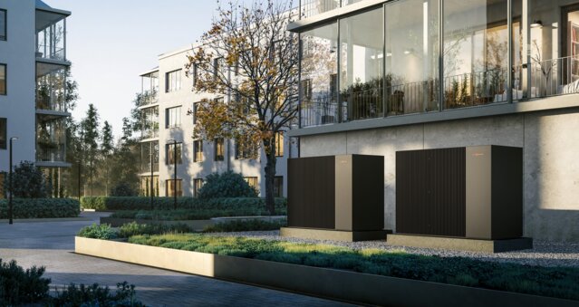 Moderne Wohnanlage mit installierten Wärmepumpen im Außenbereich – Nachhaltiges Heizen für Mehrparteienhäuse