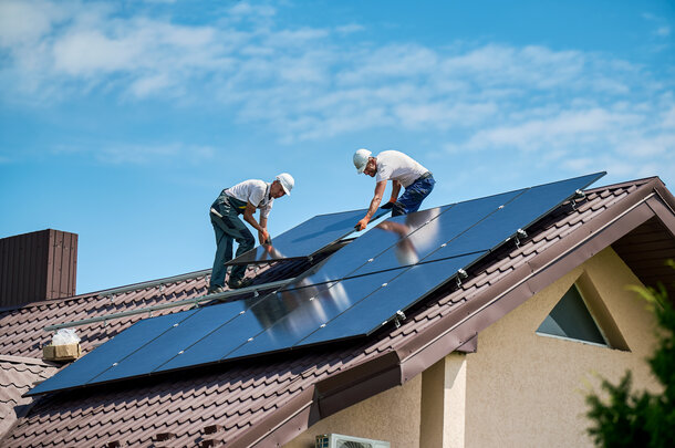 Fachhandwerker bei der Montage von Solarmodulen auf dem Dach – Ihr PV-Spezialist für München und Oberbayern