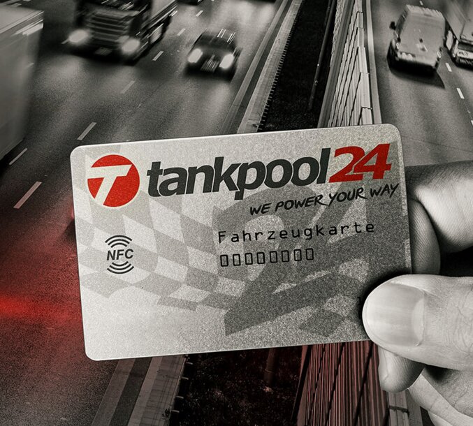 Eine Hand hält eine tankpool24 Tankkarte vor einer befahrenen Autobahn – MONTANA Tankkarten-Service für bargeldloses Tanken für Geschäftskunden