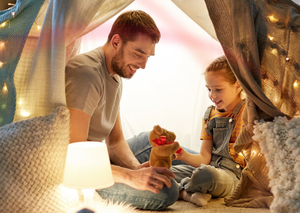 Vater und Tochter in gemütlich warmem Zuhause – günstig heizen mit Heizstrom für Wärmepumpe oder Nachtspeicherheizung