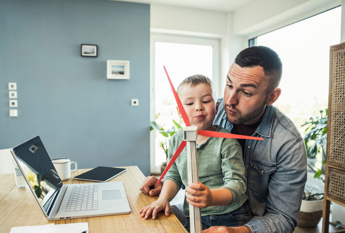 Vater und Kind am Laptop nutzen den sicheren Online-Service von MONTANA