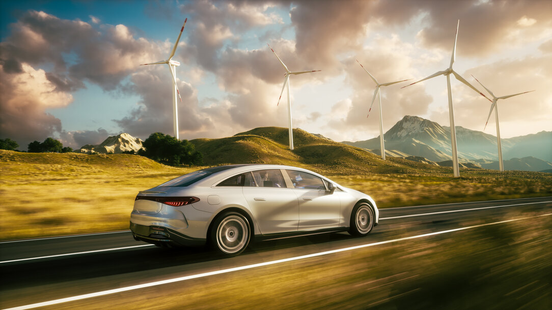 E-Auto fährt vor Windrädern – nachhaltiger Autostrom für Ihre Wallbox von MONTANA