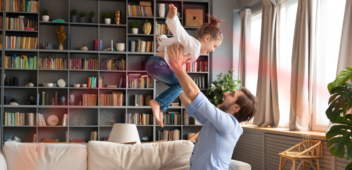 Vater hebt sein Kind spielerisch in die Luft – MONTANA Erdgas-Angebote für Ihr Zuhause