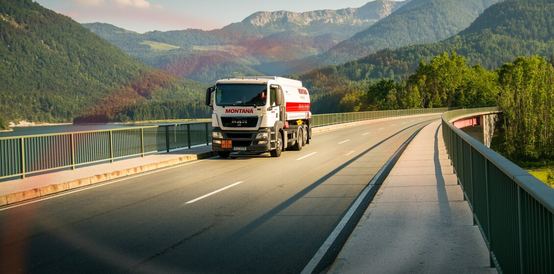 MONTANA Tankwagen auf der Straße vor Bergpanorama – Heizöl in Standard- und Premium-Qualität