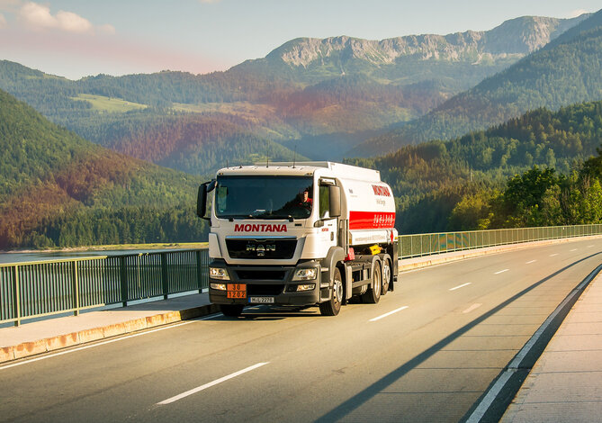 MONTANA Tankwagen auf der Straße vor Bergpanorama – Heizöl in Standard- und Premium-Qualität