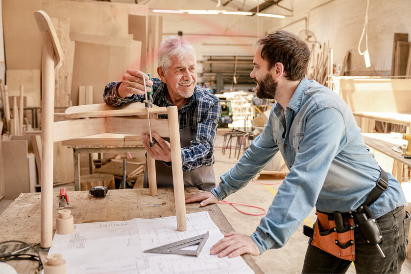 Zwei Männer im Gespräch in einer Schreiner-Werkstatt – Zuverlässige Lieferung von günstigem Heizöl für Gewerbe und Handwerk in München und Südbayern