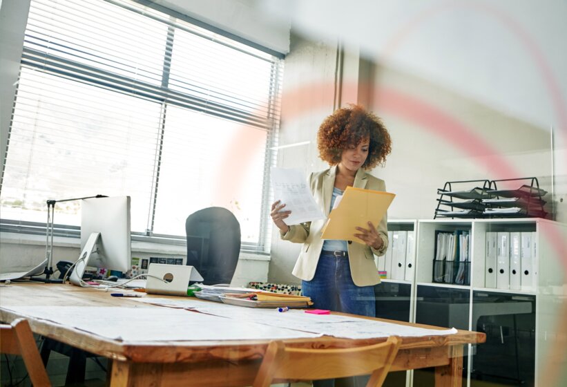 Eine Mitarbeiterin prüft Dokumente im Büro – Professioneller Mess- und Abrechnungsservice von MONTANA für die Wohnungswirtschaft