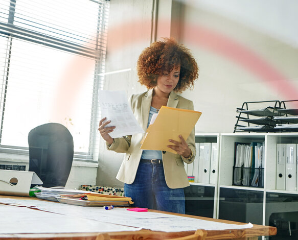 Eine Mitarbeiterin prüft Dokumente im Büro – Professioneller Mess- und Abrechnungsservice von MONTANA für die Wohnungswirtschaft