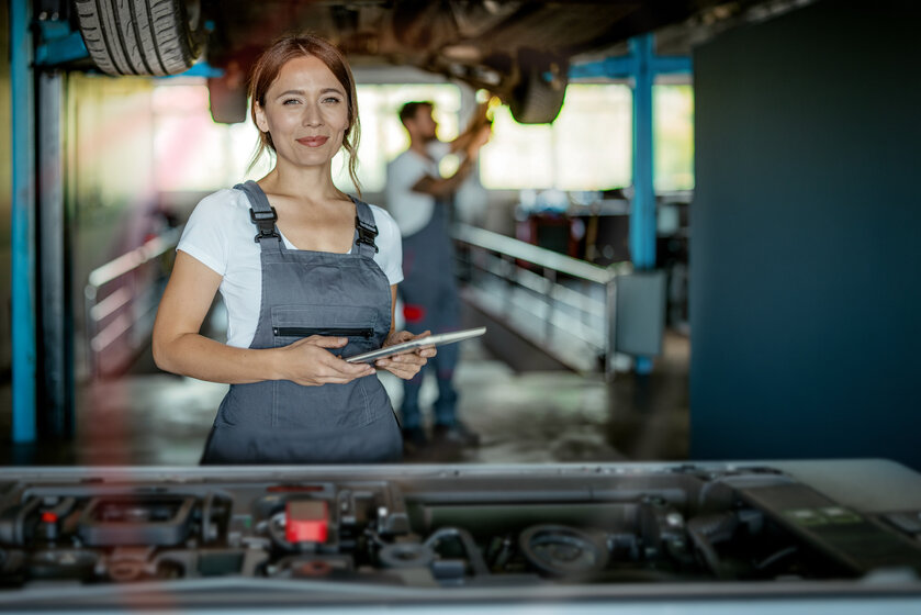 Selbstbewusste Handwerkerin in einer Kfz-Werkstatt nutzt MONTANA Gewerbestrom